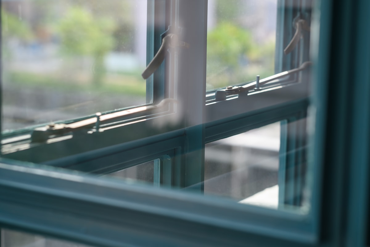 Close-up of an aluminium window frame showing the sash, handle and glazing line